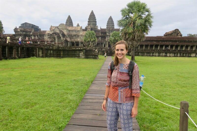 A female student stands outside of Angkor Wat.